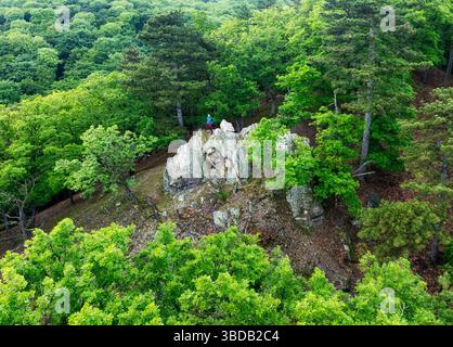 Un couple voyageur en équipement de randonnée dans les montagnes. Un des touristes sur le sommet de la montagne.randonnée dans les montagnes avec des sacs à dos. Banque D'Images