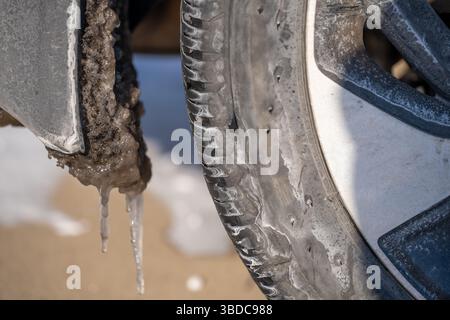 accumulation de glace et de neige sur le passage de roue du pneu arrière. Banque D'Images