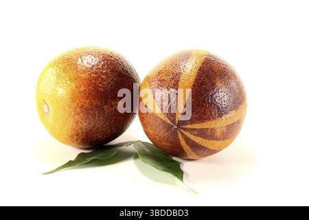 Deux oranges sanguines rouges-jaunes fraîches avec des feuilles sur un fond clair Banque D'Images