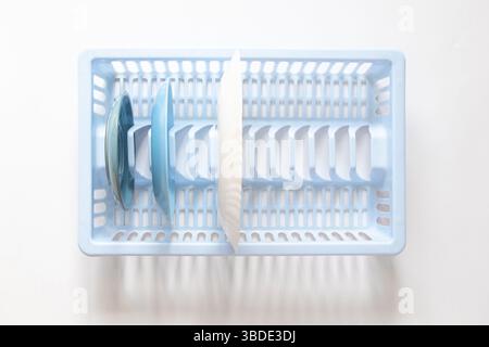 Assiettes dans un égouttoir à vaisselle en plastique bleu dans la cuisine, vue de dessus, propreté et concept de maison, vaisselle propre Banque D'Images
