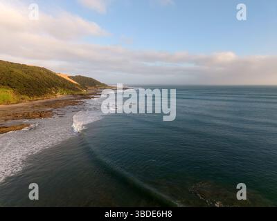 Vue aérienne des vagues de surf et des surfeurs à Ahipara Bay à l'extrémité sud de la plage de Ninety Mile à Northland, Nouvelle-Zélande Banque D'Images