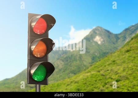 Feux de circulation contre montagne dans la campagne. Dispositif de signalisation Banque D'Images