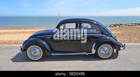 Classic Blue Volkswagen Beetle garé sur la plage de promenade en bord de mer et la mer en arrière-plan Banque D'Images