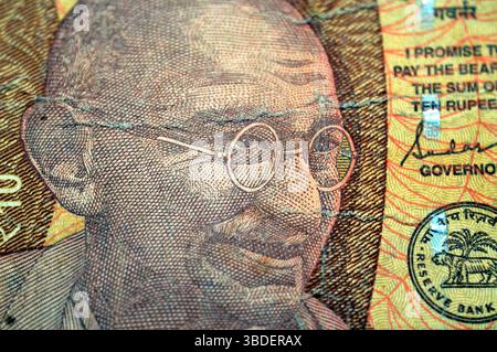 Un portrait du Mahatma Gandhi au centre gauche de l'avers de dix 10 roupies indiennes INR publié par la Reserve Bank of India, présente Telescoping se Banque D'Images