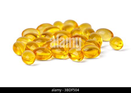 Pile de gélules molles de vitamine d jaune sur fond blanc, Banque D'Images
