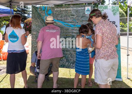 The Big Float, Portland, Oregon - 14 juillet 2018 : les gens se rassemblent autour d'une carte du bassin versant pour en apprendre davantage sur les voies navigables locales et l'importance des inconvénients des rivières Banque D'Images