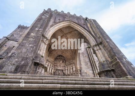 Une vue en bas angle capture l'imposante arche principale et l'entrée détaillée de la cathédrale Santa Maria de Tui, en Espagne, un témoignage de son arche historique Banque D'Images
