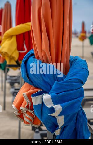 Deauville, France - 05 17 2025 : plage de Deauville. Vue détaillée de la plage avec parasols colorés, transats, mer et ciel bleu nuageux Banque D'Images