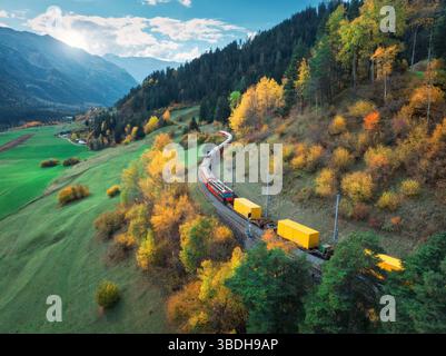 Vue aérienne du train rouge moderne avec des wagons de fret jaunes Banque D'Images