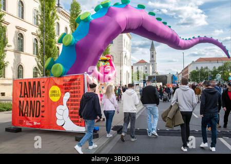 Zamanand Festival auf der Ludwigstraße, Samstagnachmittag, 24. Mai 2025 Deutschland, München, 24. Mai 2025 Zamanand Festival auf der Ludwigstraße, Themen unter anderem Klima- und Umweltschutz, viele Münchner feiern mit beim Straßenfest zwischen Siegestor und Odeonsplatz, Samstagnachmittag, Blick Richtung Ludwig-Maximilians-Universität und Ludwigskirche, vorn ein Deko-Drachenschwanz, Frühlingstag, Ludwigstraße, Bayern *** Zamanand Festival le 24 mai, Allemagne, 24 mai 2025, Munich après-, après-midi 24 mai 2025 Festival de Zamanand sur Ludwigstraße, les sujets incluent le climat et la protection de l'environnement, l'homme Banque D'Images