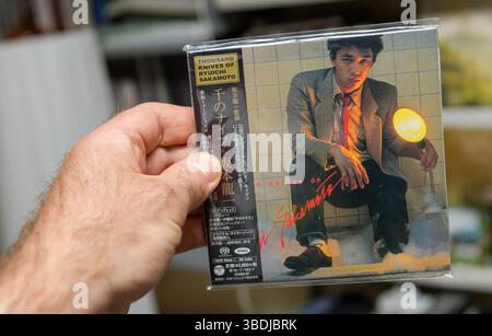Paris, France - 14 avril 2025 : AJapanese Super Audio CD de Ryuichi Sakamoto Thousand Knives tenu à la main, avec la couverture originale de 1978 et tra Banque D'Images
