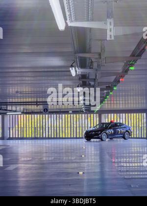 Dijon, France - 12 avril 2025 : une berline noire Skoda Superb Taxi est garée dans un garage presque vide avec des capteurs de plafond affichant des lumières vertes et rouges au-dessus de chaque emplacement Banque D'Images
