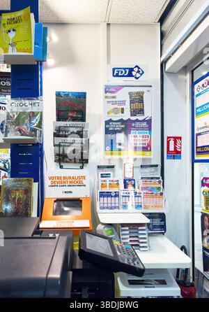 Dijon, France - 12 avril 2025 : billets de loterie, signalétique FDJ, terminal de paiement et guichet bancaire nickel sont visibles au comptoir d'un kiosque français, entourés de supports imprimés Banque D'Images