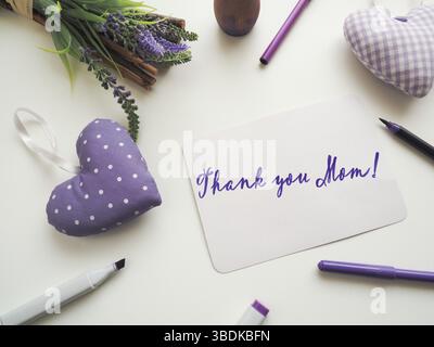 Merci mère comme brossette lettrage sur une carte de voeux de fête des mères sur une table blanche avec décoration, Happy Mothers Day Banque D'Images