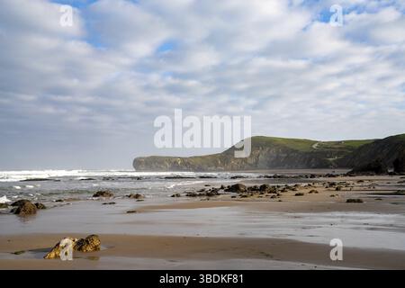 Une vue panoramique sur la plage de sable sauvage et rocheuse à marée basse Banque D'Images