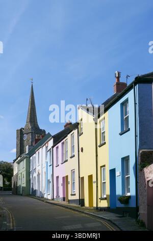 L'étroite rue Cresswell avec des chalets colorés et l'église St Mary en arrière-plan, Tenby, Pembrokeshire, pays de Galles, Royaume-Uni Banque D'Images