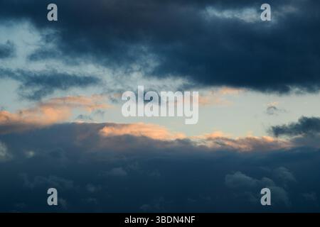 Nuages moelleux. Ciel bleu pendant la journée. Le temps est mauvais. La lumière traverse les nuages. Photo horizontale universelle. L'image d'arrière-plan. Banque D'Images