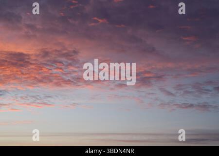 Photo verticale universelle. Couches de coucher de soleil. Nuages moelleux. Ciel romantique. L'image d'arrière-plan. Banque D'Images