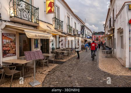 Lagos, Algarve, Portugal - 19 octobre 2023 : les gens sur Rua 25 de Abril rue piétonne pavée dans la vieille ville avec des restaurants et des boutiques. Banque D'Images