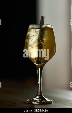 cocktail avec citron et glace dans un verre sur fond sombre Banque D'Images
