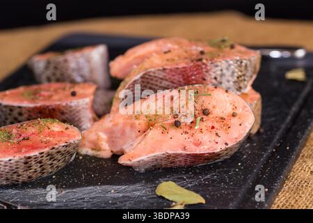 Morceaux crus de poisson rouge avec assaisonnements. Banque D'Images