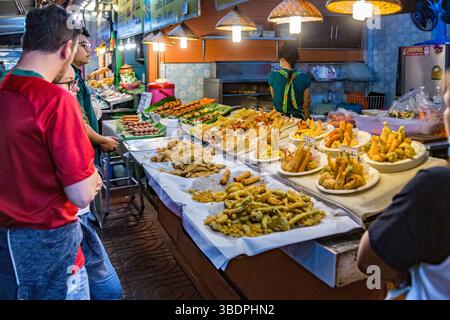 Les clients regardent sur les choix de fruits de mer frits frais au marché de nuit dans le centre-ville de Chiang Rai, Thaïlande. Banque D'Images