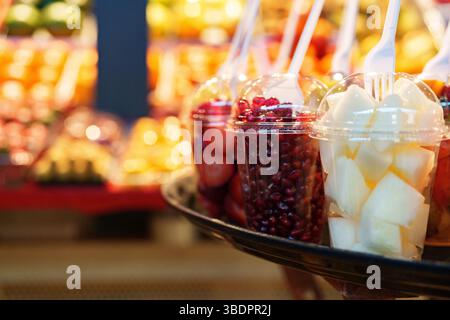 Coupes de fruits frais exposées sur un stand de marché animé pendant un après-midi ensoleillé en été Banque D'Images