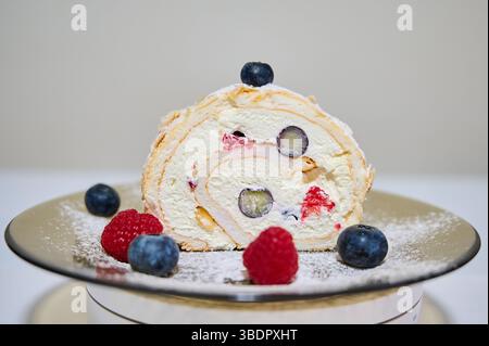 Rouler le gâteau avec la crème, la framboise et les myrtilles Banque D'Images
