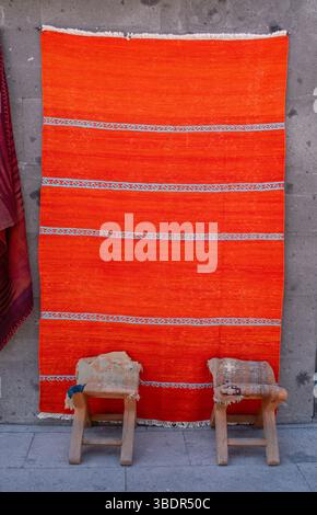 Turquie : deux tabourets en bois et un tapis tissé à la main dans l'une des boutiques d'artisanat locales de Cappadoce, région historique de l'Anatolie centrale Banque D'Images