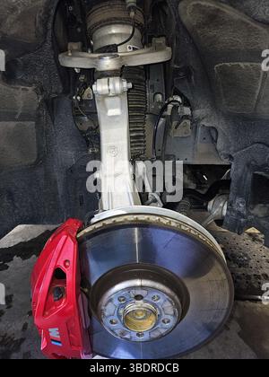 Ottawa, ON Canada - 03.02.2024 : système de suspension de voiture détaillant un disque de frein, un étrier et une jambe de suspension en exposition. Banque D'Images