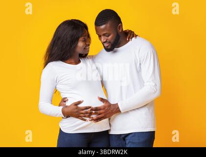 L'homme dans l'amour de toucher son ventre de femme enceinte Banque D'Images