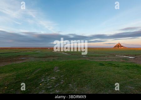 Vue ultra grand angle sur la baie du Mont Saint-Michel, avec Tombelaine, la pointe de Carole et les polders à l'heure dorée (coucher de soleil), le Mont St-Michel, Banque D'Images