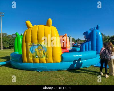 Toronto, ON, Canada – 31 mai 2024 : les familles se rassemblent autour de grands toboggans gonflables et de parcours d’obstacles lors d’un événement pour enfants par un après-midi ensoleillé. Banque D'Images