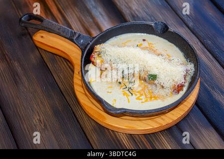 Une lasagne italienne copieuse et savoureuse, servie chaude dans un moule rustique i, avec une sauce tomate riche, de la viande assaisonnée, de la béchamel crémeuse et du fromage fondu Banque D'Images