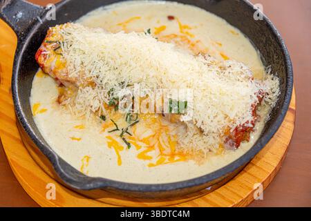 Une lasagne italienne copieuse et savoureuse, servie chaude dans un moule rustique i, avec une sauce tomate riche, de la viande assaisonnée, de la béchamel crémeuse et du fromage fondu Banque D'Images