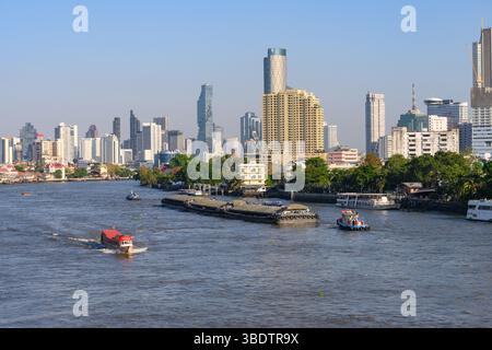 Bangkok, Thaïlande. 05 mars 2025. Bateaux vus sur la rivière Chao Phraya avec la ligne d'horizon moderne de la ville des immeubles de bureaux et d'appartements de grande hauteur. (Photo de John Wreford/SOPA images/SIPA USA) crédit : SIPA USA/Alamy Live News Banque D'Images