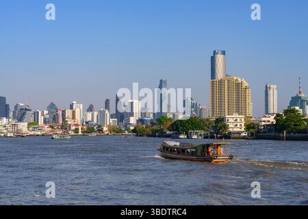 Bangkok, Thaïlande. 05 mars 2025. Bateaux vus sur la rivière Chao Phraya avec la ligne d'horizon moderne de la ville des immeubles de bureaux et d'appartements de grande hauteur. (Photo de John Wreford/SOPA images/SIPA USA) crédit : SIPA USA/Alamy Live News Banque D'Images