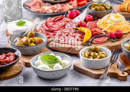 Hors-d'œuvre assortis et plateaux d'antipasti sur plateau en bois, concept traiteur avec viandes et fromages Banque D'Images