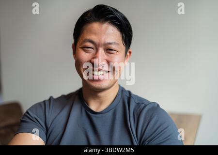 Portrait d'un jeune bel homme asiatique, regardant la caméra. Banque D'Images