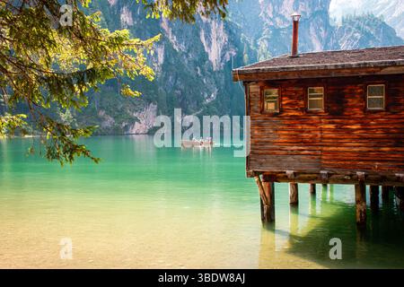 Maison traditionnelle en bois nichée dans les montagnes, entourée par la nature, le silence, et des sommets à couper le souffle sous un ciel dégagé dans un cadre intemporel. Banque D'Images