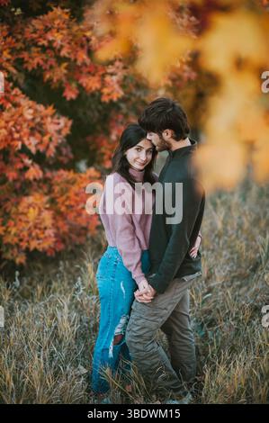 Couple aimant profite de moment d'automne paisible par des arbres colorés Banque D'Images