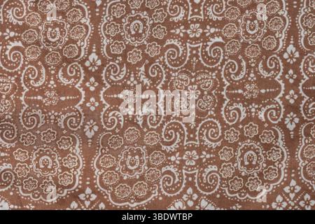 Tissu beige vintage avec un petit motif blanc géométrique. Partie d'une écharpe en coton. Banque D'Images