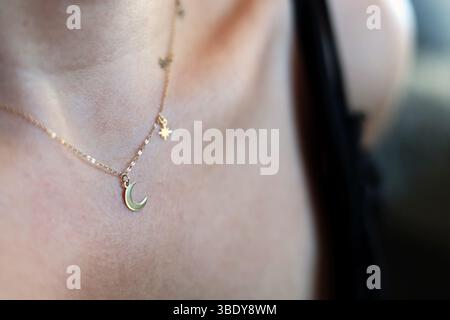 Belle lune d'or et collier d'étoiles sur le cou d'une jeune femme Banque D'Images
