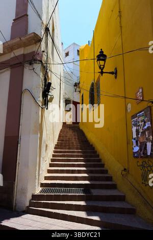 Guanajuato City, Mexique - 30 mai 2016 : un long escalier entre les bâtiments avec un mur jaune sur la droite, menant à une porte rouge en haut. Banque D'Images