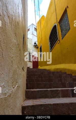 Guanajuato City, Mexique - 30 mai 2016 : une ruelle étroite avec des marches en pierre menant entre des bâtiments colorés. Banque D'Images