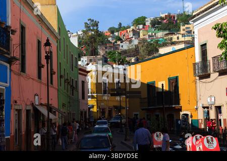 Guanajuato City, Mexique - 30 mai 2016 : les gens marchent le long d'une rue bordée de bâtiments colorés et de magasins, y compris un KFC, dans la ville de Guanajuato. Banque D'Images