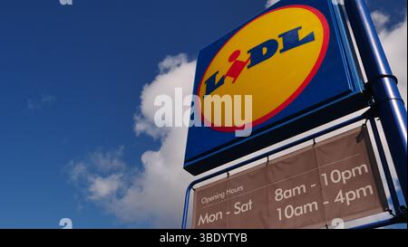 Le logo et la signalétique de l'épicerie Lidl sur fond de ciel bleu Banque D'Images