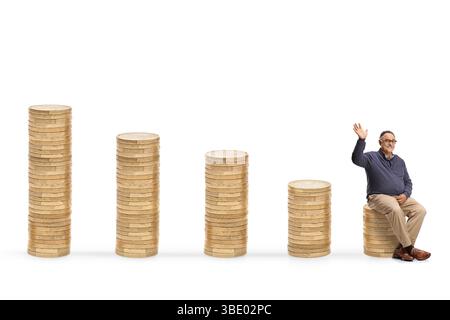 Homme mûr occasionnel agitant et assis sur un tas de pièces de monnaie isolé sur fond blanc Banque D'Images