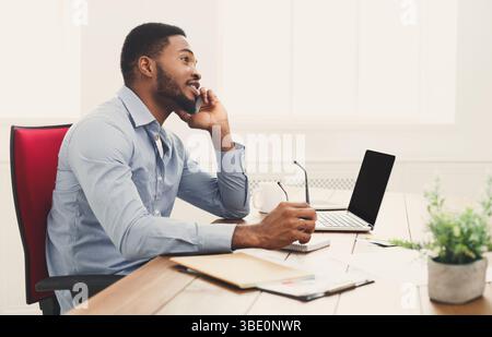 Jeune homme d'affaires noir parlant sur téléphone portable Banque D'Images