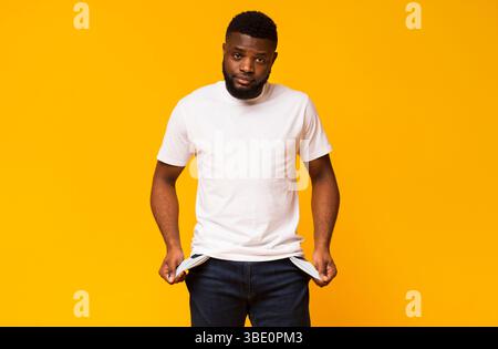 Triste pauvre african american man showing poches vides Banque D'Images